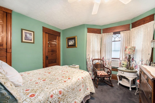 bedroom with cooling unit, ceiling fan, carpet floors, and a textured ceiling