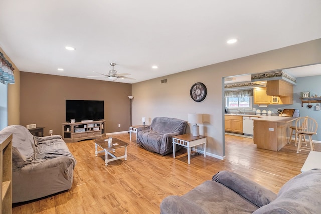 living room with light wood-type flooring and ceiling fan