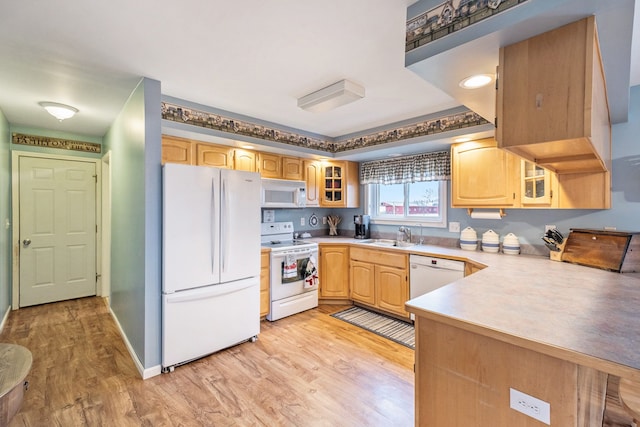 kitchen featuring kitchen peninsula, sink, white appliances, and light wood-type flooring