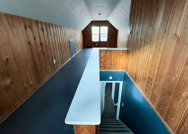 additional living space featuring wood walls and lofted ceiling