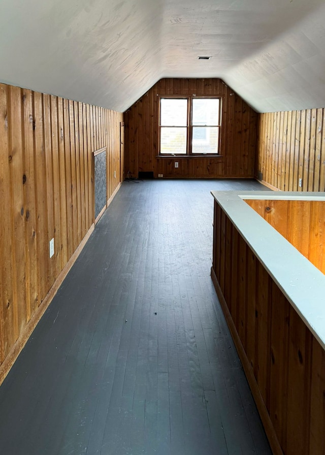 bonus room with hardwood / wood-style floors, lofted ceiling, and wood walls