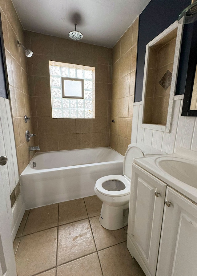 full bathroom featuring tile patterned flooring, vanity, tiled shower / bath combo, and toilet