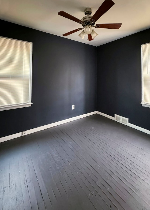 empty room with dark hardwood / wood-style floors and ceiling fan