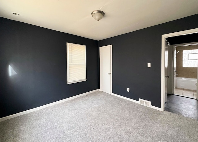 unfurnished bedroom featuring carpet and ensuite bath