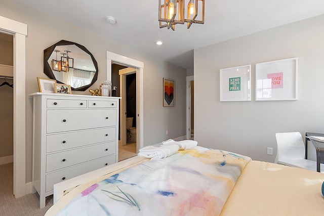 carpeted bedroom featuring ensuite bathroom and a spacious closet