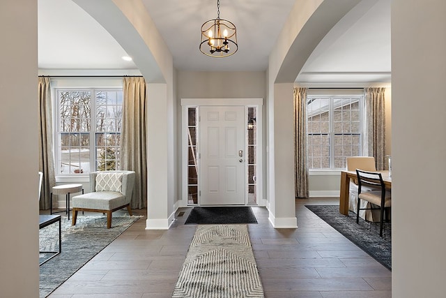 foyer entrance featuring dark wood-type flooring and a chandelier