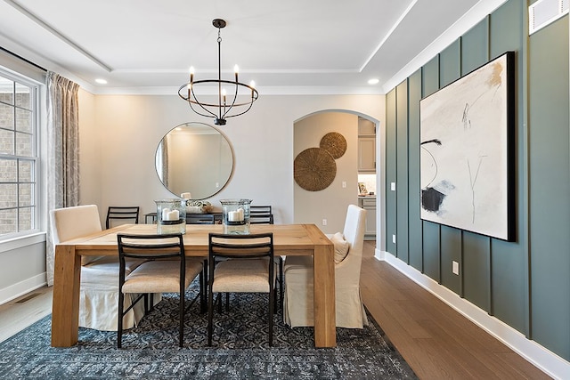 dining room with a notable chandelier, dark hardwood / wood-style flooring, and a tray ceiling