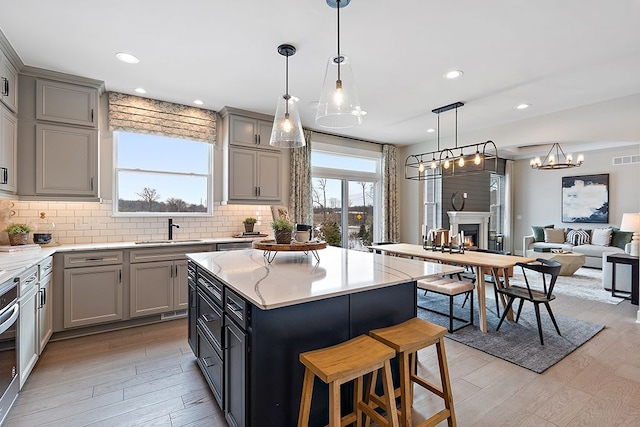 kitchen with gray cabinets, a center island, and hanging light fixtures