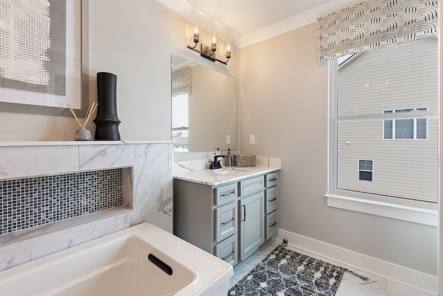 bathroom featuring ornamental molding, vanity, and a bathing tub