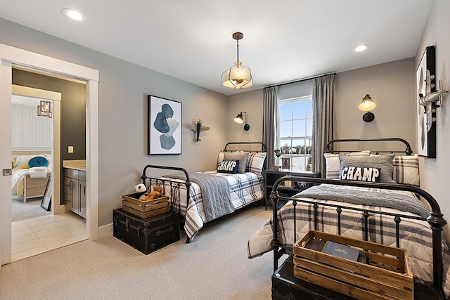 bedroom with connected bathroom and light colored carpet