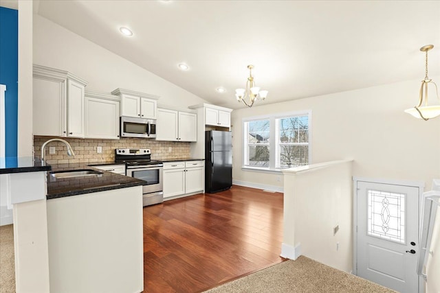 kitchen with white cabinetry, sink, hanging light fixtures, stainless steel appliances, and tasteful backsplash