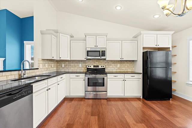 kitchen with sink, vaulted ceiling, dark hardwood / wood-style floors, white cabinetry, and stainless steel appliances