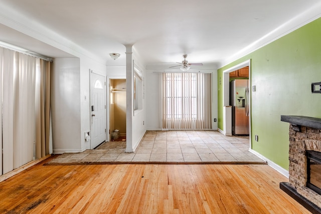 unfurnished living room featuring ceiling fan, a fireplace, and light hardwood / wood-style flooring