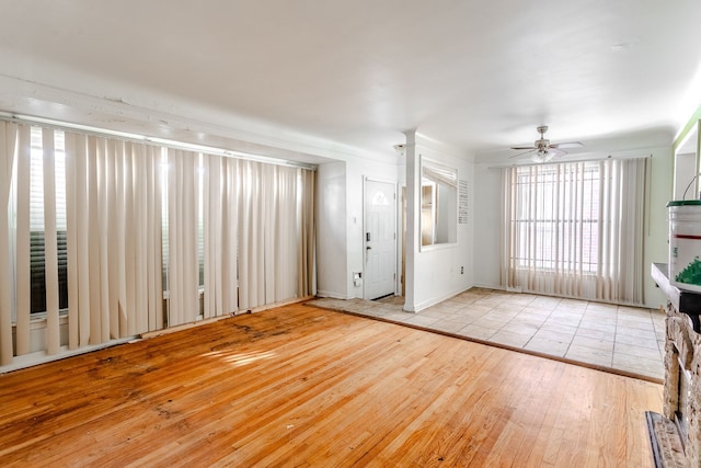 unfurnished living room featuring light wood-type flooring and ceiling fan