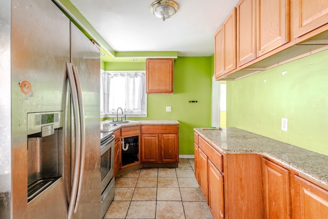 kitchen featuring light tile patterned floors, stainless steel appliances, light stone counters, and sink