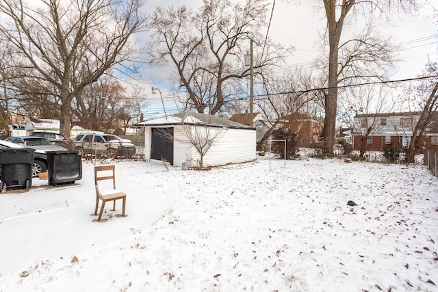 snowy yard featuring a shed