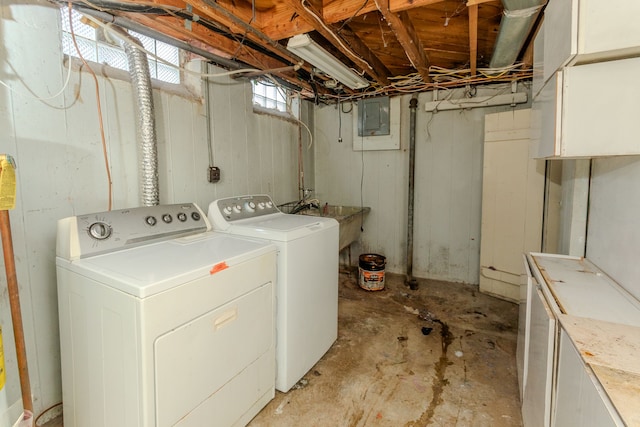 clothes washing area with electric panel, separate washer and dryer, and sink