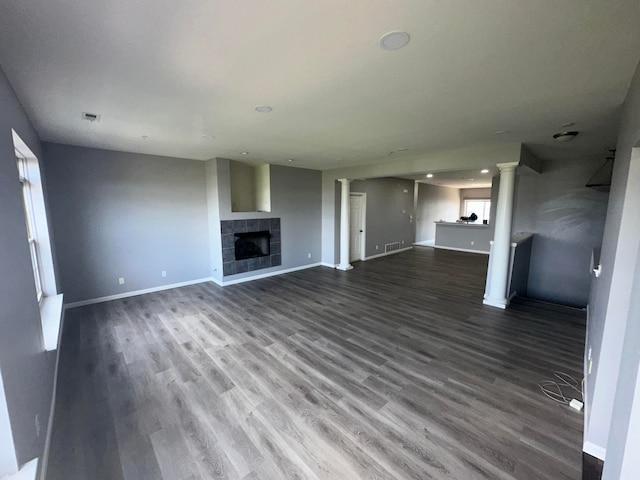 unfurnished living room with a tile fireplace and wood-type flooring