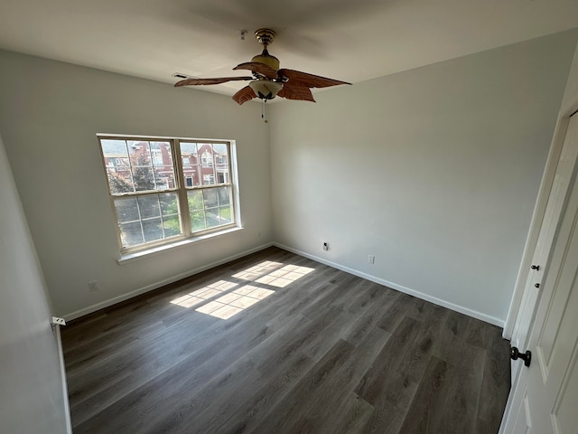 unfurnished room with ceiling fan and dark wood-type flooring