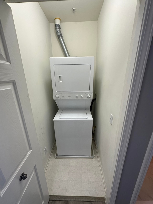 clothes washing area with stacked washer and clothes dryer