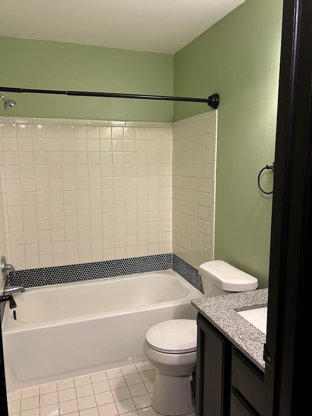 full bathroom featuring toilet, vanity, tile patterned floors, and tiled shower / bath