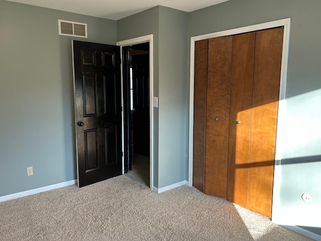 unfurnished bedroom with light carpet and a closet