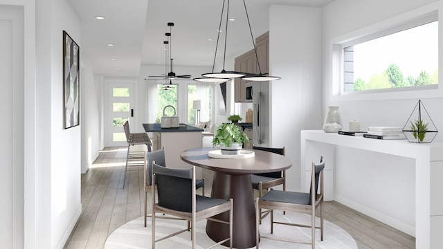 dining area featuring light wood-type flooring, plenty of natural light, and ceiling fan