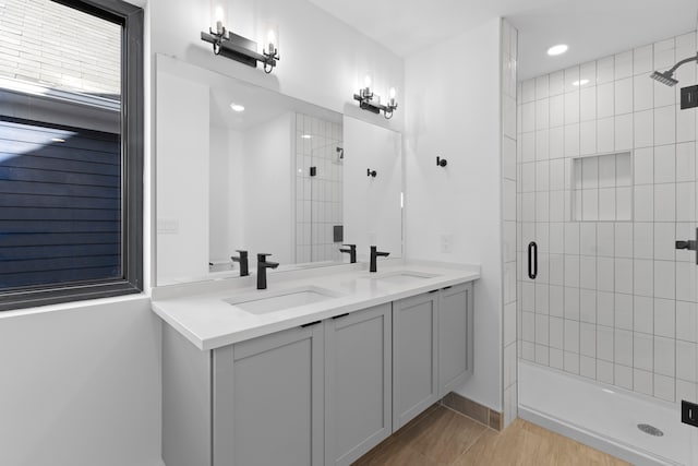 bathroom with wood-type flooring, vanity, and an enclosed shower