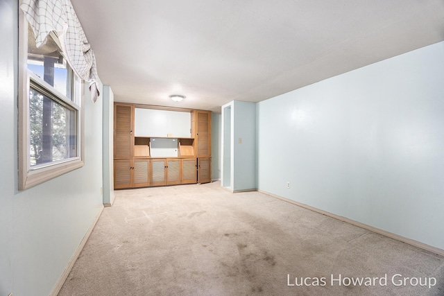 unfurnished living room featuring light colored carpet