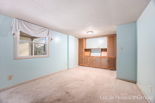 unfurnished room with light carpet and a textured ceiling