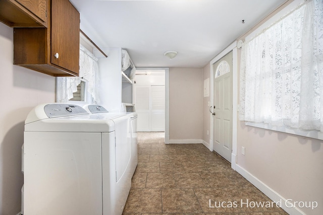 washroom with washer and dryer and cabinets