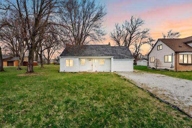 outdoor structure at dusk featuring a lawn