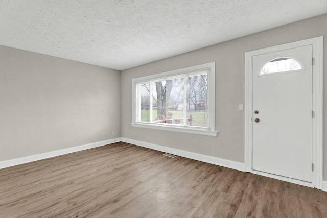 foyer featuring light hardwood / wood-style floors and a textured ceiling