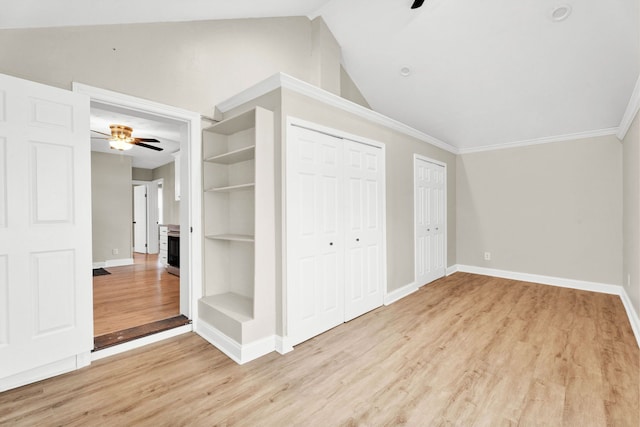 interior space featuring built in shelves, light hardwood / wood-style floors, lofted ceiling, and ceiling fan