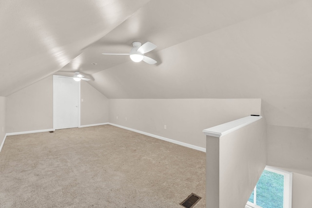 additional living space featuring light carpet, vaulted ceiling, and ceiling fan