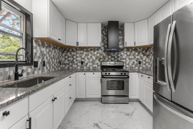 kitchen featuring backsplash, white cabinets, wall chimney range hood, sink, and appliances with stainless steel finishes