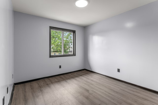 unfurnished room featuring hardwood / wood-style flooring