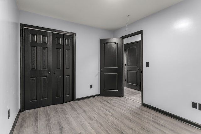 unfurnished bedroom with a closet and light hardwood / wood-style flooring