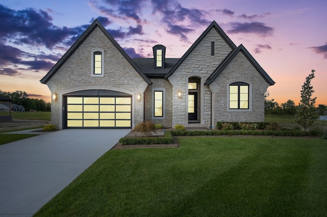 french country home with a lawn and a garage