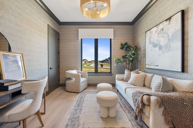 living room featuring an inviting chandelier, ornamental molding, and light hardwood / wood-style flooring