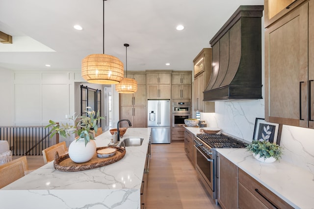 kitchen with a large island with sink, sink, custom range hood, and appliances with stainless steel finishes