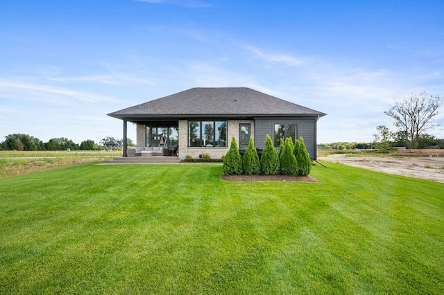 rear view of house with a patio area and a lawn