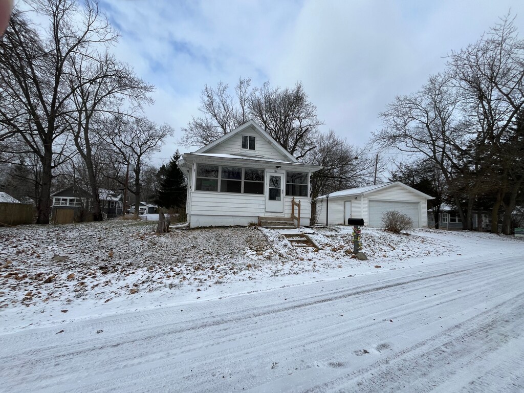 view of front of property with a garage and an outdoor structure