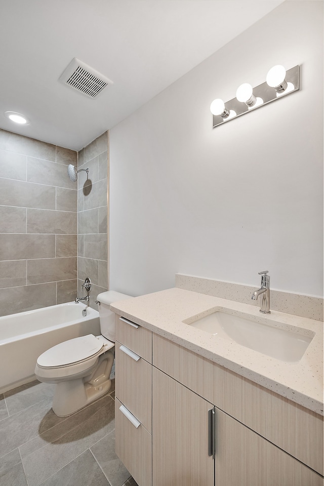 full bathroom featuring tile patterned floors, vanity, toilet, and tiled shower / bath