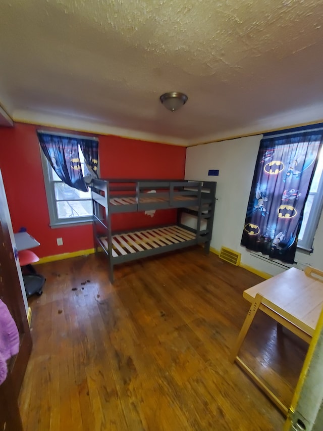 bedroom with a textured ceiling and hardwood / wood-style flooring