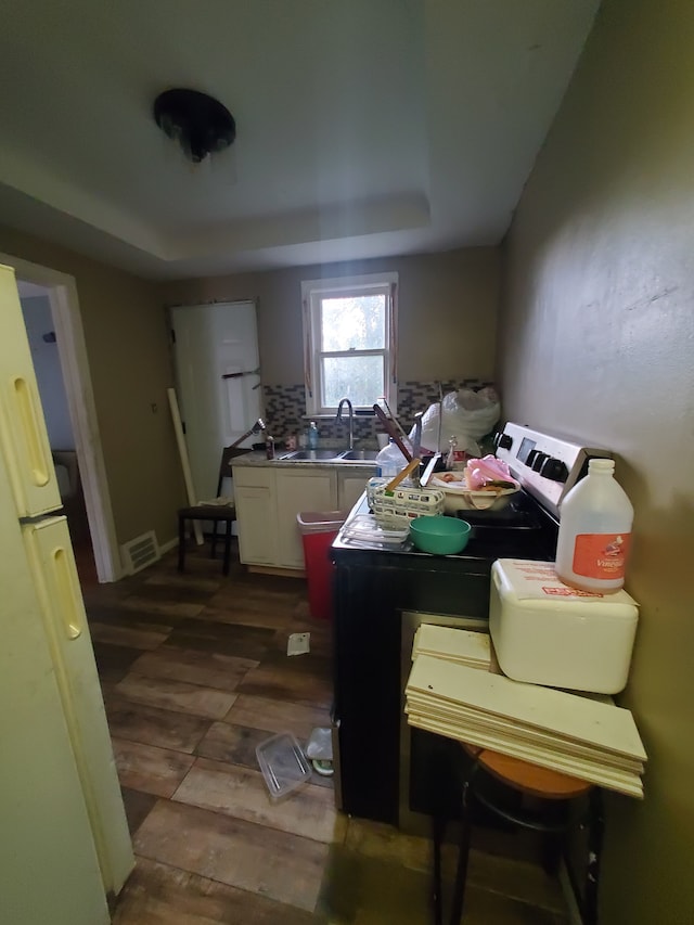 kitchen featuring white cabinets, dark hardwood / wood-style floors, white appliances, and sink