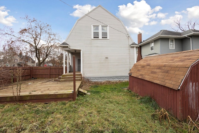 rear view of house featuring a lawn and a wooden deck