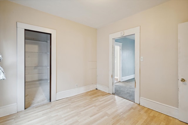 unfurnished bedroom with light hardwood / wood-style floors and a closet