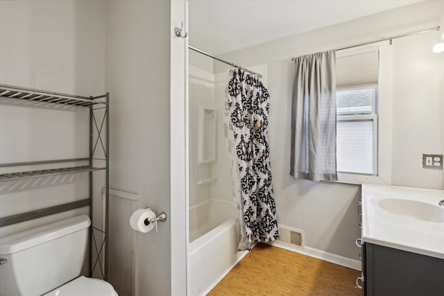 full bathroom featuring hardwood / wood-style floors, vanity, shower / bath combo, and toilet