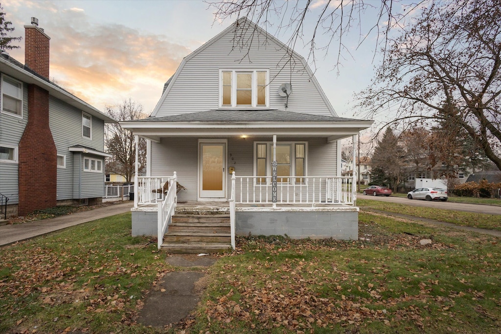 bungalow featuring a porch and a yard